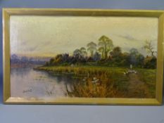 HENRY K FOSTER oil on canvas - lakeside village scene with a figure tending geese, 44 x 79.5cms