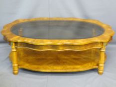 REPRODUCTION WALNUT EFFECT COFFEE TABLE having a shaped top with glass insert, on segmented and