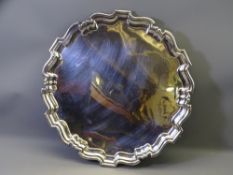 CIRCULAR SILVER TRAY, uninscribed with wavy border and four scrolled supports, 42cms diameter, 55
