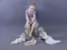 NAO/LLADRO FIGURINES, three recumbent figures of children and a larger NAO seated figurine of a
