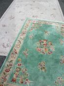 TWO CONTINENTAL WOOLLEN RUGS including a Chinese washed woollen example, green ground with single