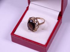 9CT GOLD SMOKEY QUARTZ DRESS RING, the oval facet cut stone set in a raised openwork mount, 3.2grms,