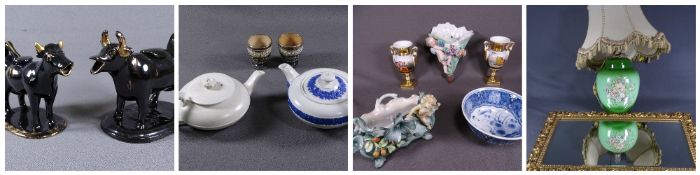 TWO BLACK JACKFIELD COW CREAMERS, one large and the smaller with gilt decoration, each on oval bases