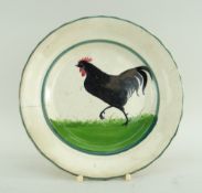 LLANELLY POTTERY SIDE-PLATE PAINTED WITH STRUTTING BLACK COCK on sponged grass within two green