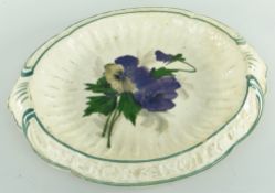 RARE LLANELLY POTTERY BREAD PLATE painted with pansies, the interior of fluted form, the sloped