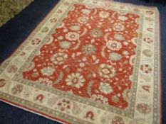 ORIENTAL RUG decorated with palmettes on a coral field, 240 x 300cms