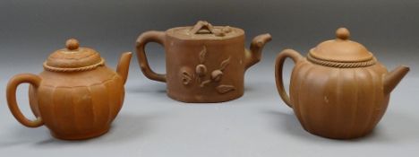 THREE CHINESE YIXING TEAPOTS WITH COVERS, 12cms H the tallest