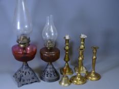 TWO IRON BASED OIL LAMPS, one with Amber glass and one with Cranberry glass reservoirs, two pairs of