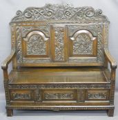 ANTIQUE STYLE OAK CARVED BOX SEAT SETTLE, the top rail with carved initials to the shield over a