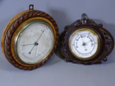 TWO WALL HANGING CARVED BAROMETERS, 29cms diameter the larger