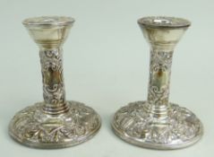 PAIR OF FILLED SILVER DWARF CANDLESTICKS of circular shape featuring bird and scroll repousse