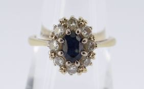 18CT GOLD SAPPHIRE & DIAMOND CLUSTER RING, the central sapphire (0.6 x 0.4cms) surrounded by eight