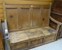 EARLY 19TH CENTURY PINE BOX SETTLE, with panelled back and down swept arms, hinged seat section,