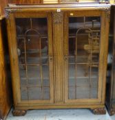 1930s OAK BOOKCASE with astragal glazed doors and foliate carved ornament, 106 x 35 x 128cms