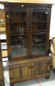 NIGEL GRIFFITHS STAINED OAK BOOKCASE, with leaded glazed doors and cupboard base, 92 x 152cm