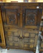NIGEL GRIFFITHS STAINED OAK DRINKS CABINET, with two Flemish style carved panels of monks above