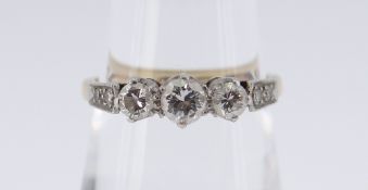 18CT GOLD & PLATINUM DIAMOND RING, the three central diamonds flanked by diamond chip shoulders,
