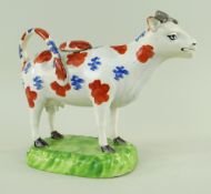 A SWANSEA CAMBRIAN POTTERY COW CREAMER with tail as loop handle, standing on a moulded oval base,