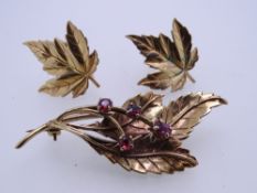 A 9CT GOLD LEAF BROOCH with four garnets and a pair of screw-fit nine carat gold earrings, total