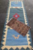 TWO EASTERN STYLE WOOLLEN CARPETS to include a small scatter rug with traditional pattern on brown