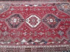 EASTERN WOOLLEN CARPET red ground with traditional central block pattern and multi-bordered