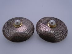 A PAIR OF 925 BEATEN SILVER 'DISC' EARRINGS, each with an offset single pearl set in a yellow