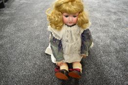 An early 20th century Armand Marseille bisque headed doll having sleep eyes, open mouth with four