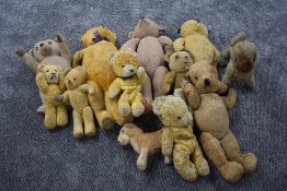 An early 20th century straw filled teddy bear having hump back and pointed snout, leather pads and