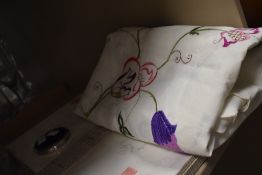 Two embroidered pillow cases, a tablecloth and a blue Stratton compact.