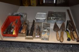 A selection of masonry and similar building tools including trowls and chisels