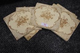 A set of seven early 20th century fireplace surround tiles having floral transfer pattern.