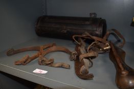 A pair of antique ice skates, a pair of spurs and a wall mounted candle tin.