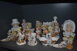 A selection of antique hard paste and bisque figurines including posy vase, garnitures and vesta,