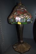 A Tiffany style table top lamp with cast base