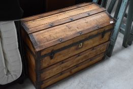 A traditional wooden dome topped trunk, with metal strapping and stud work stripe lined interior,