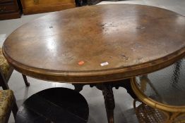 A Victorian walnut loo table, on four splay legs with pot casters, veneer lifting and flaking in
