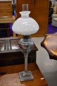 An oil lamp , on Corinthian column base, having opaline shade and clear chimney, approx. overall