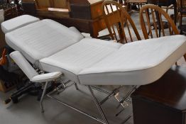 A modern white leather consultation couch, possible medical or beauty treatment use