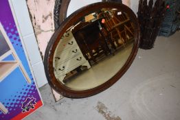 An early 20th Century oval mirror, approx, diameter 92cm