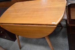 A light stain Ercol style splay legged drop leaf dining table