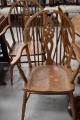 A pair of traditional light stain wheel back carver chairs