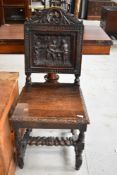 A 19th Century oak hall chair having heavily carved back, pictorial decoration depicting tavern