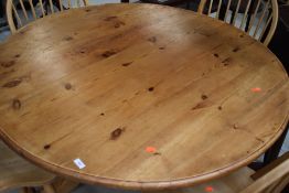 A traditional pine circular dining table, on carved triple splay legs , diameter approx. 120cm