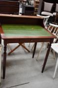 A reproduction ladies writing desk, having leather skiver top and freize drawers