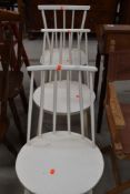 A set of three vintage painted kitchen chairs having rail and stick backs, in the Ercol style