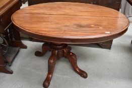 A Victorian mahogany loo style table, oval top over quadruple carved splay legs and scroll feet,