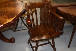 A traditional stained frame solid seated smokers bow style armchair