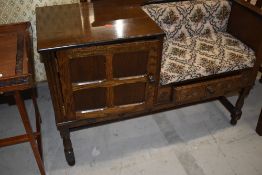 A traditional telephone seat having side panelled cupboard and under seat drawer, width approx.