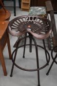 A cast adjustable stool, modelled as vintage tractor or implement seat, with bronze effect finish