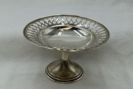 A small silver tazza having pierced decoration to rim of plain bowl on circular stepped pedestal,